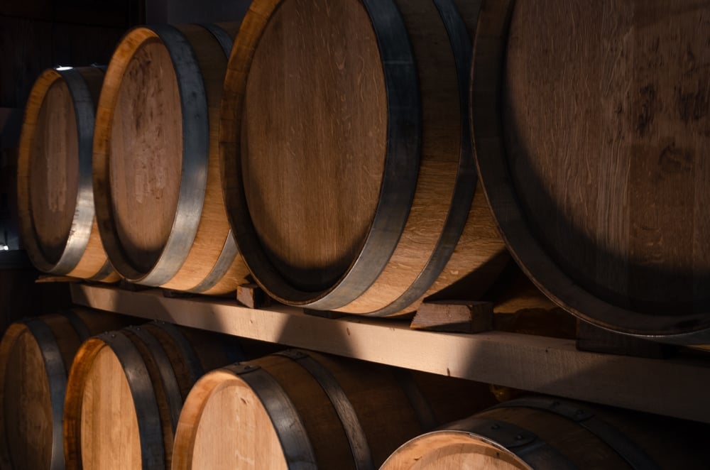 a,moody,,warm toned,shot,of,wooden,wine,barrels,stacked,in